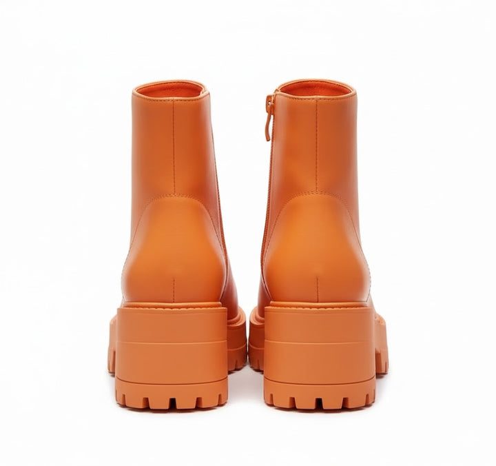 Orange synthetic women's platform ankle boots with side zippers and thick lug soles.